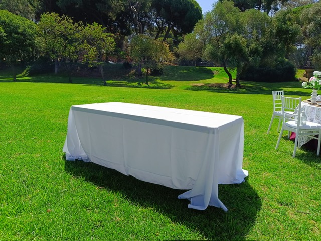 Mesa rectangular vestida con mantel blanco