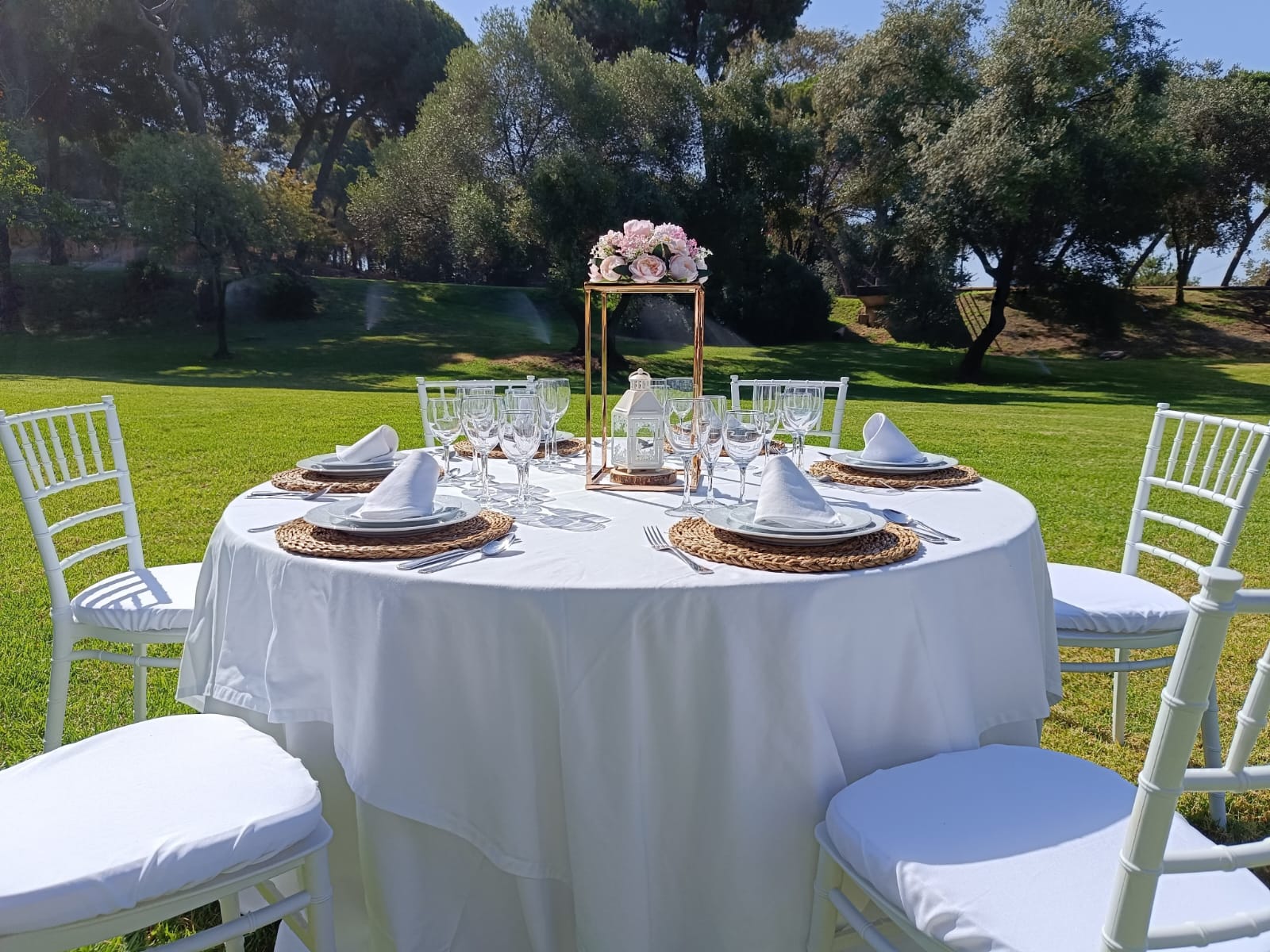 Mesa redonda vestida con mantel y cubre blanco para un evento